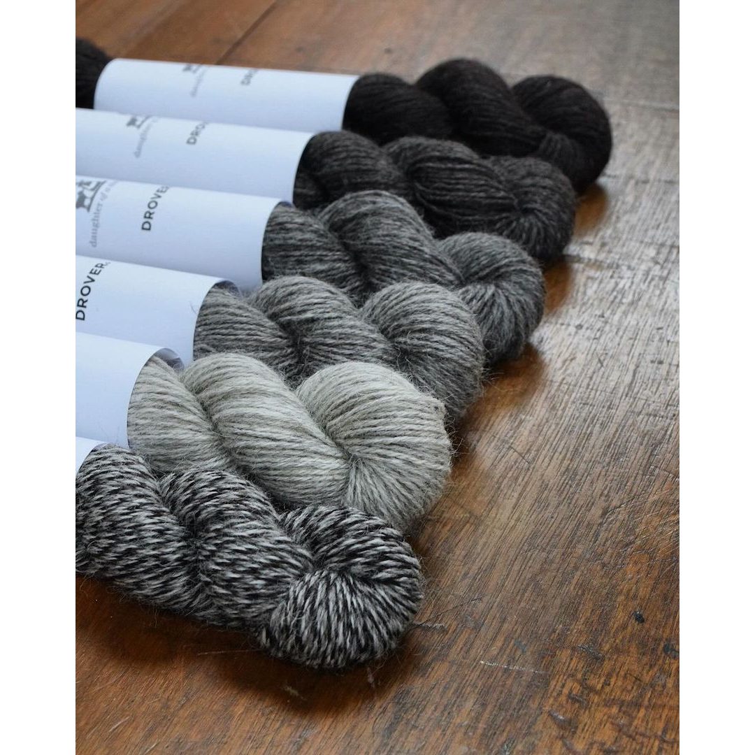 6 skeins of naturally coloured wool yarn ranging from light grey to black