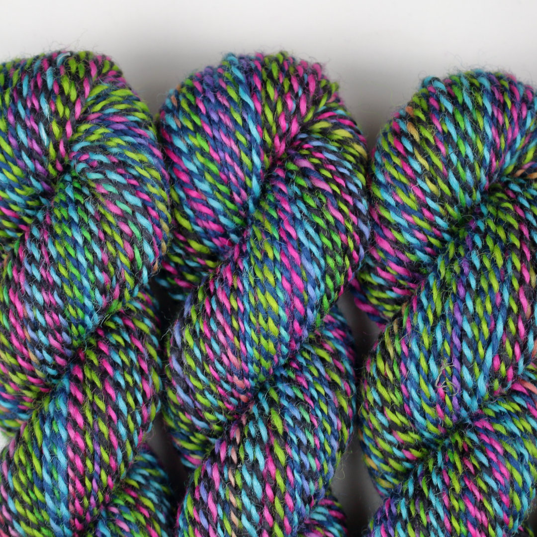 Black, lime, and hot pink marled skeins of Chimera