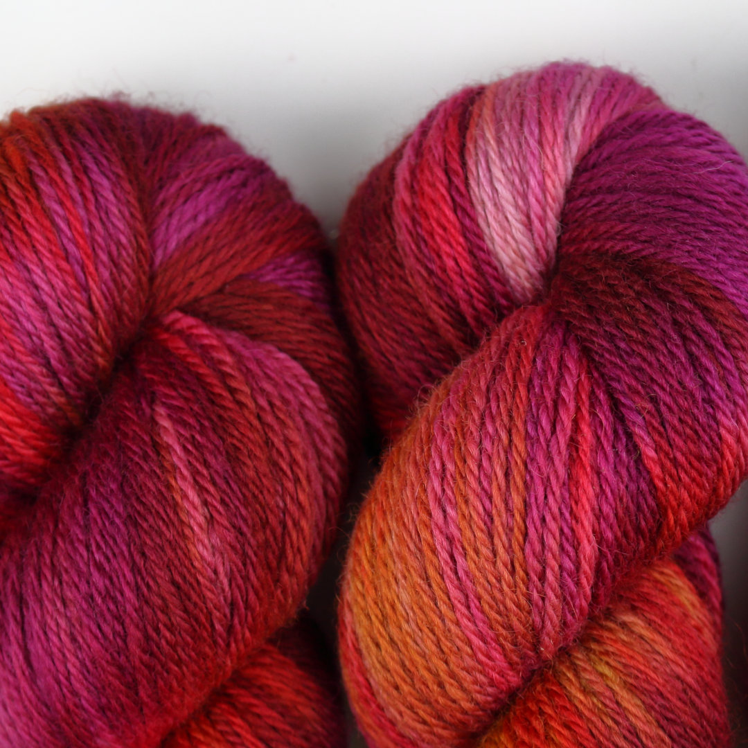Close up of variegated skeins of rich plum purples and reds.