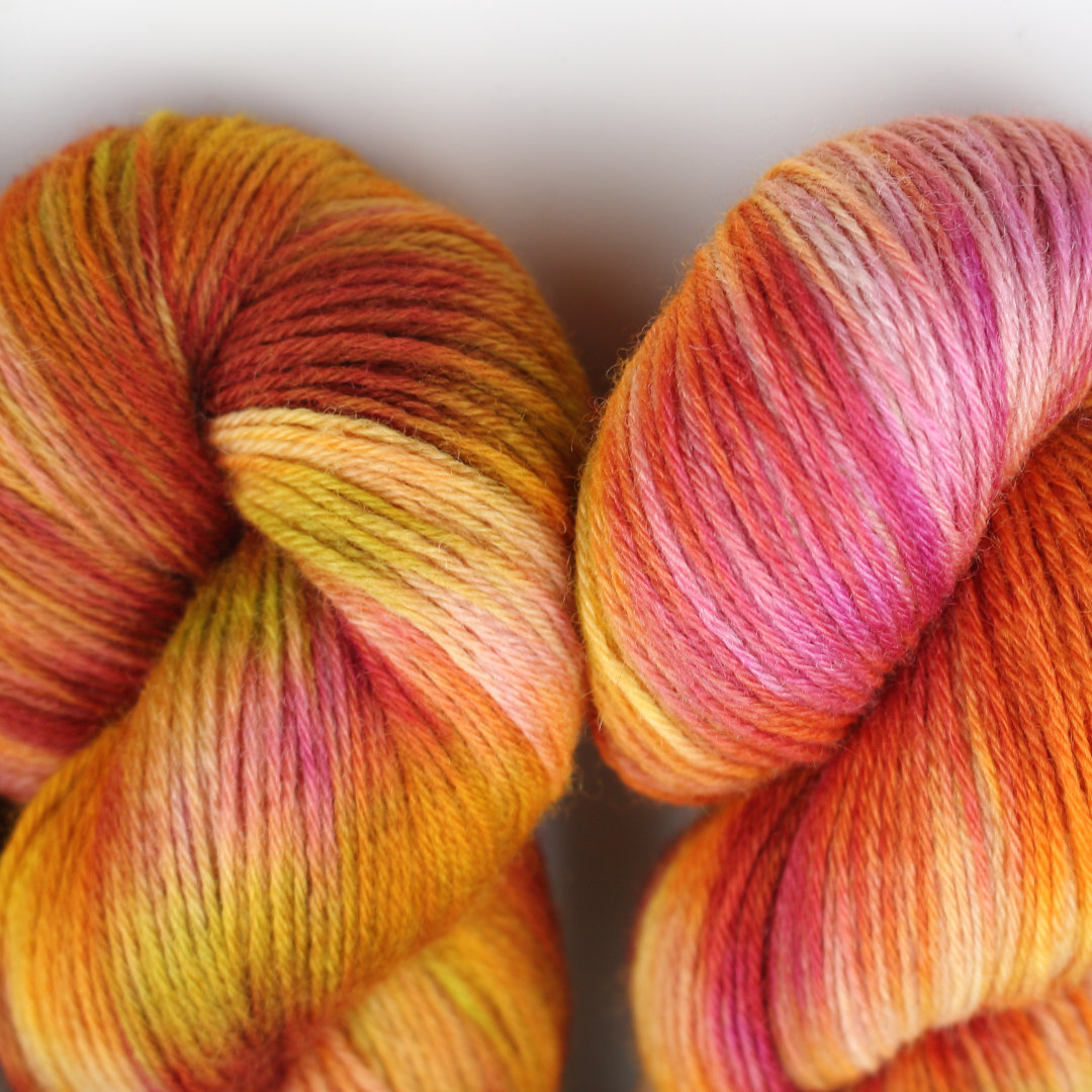 Close up of variegated skeins of rhubarb colours, purples, creams, and greens.