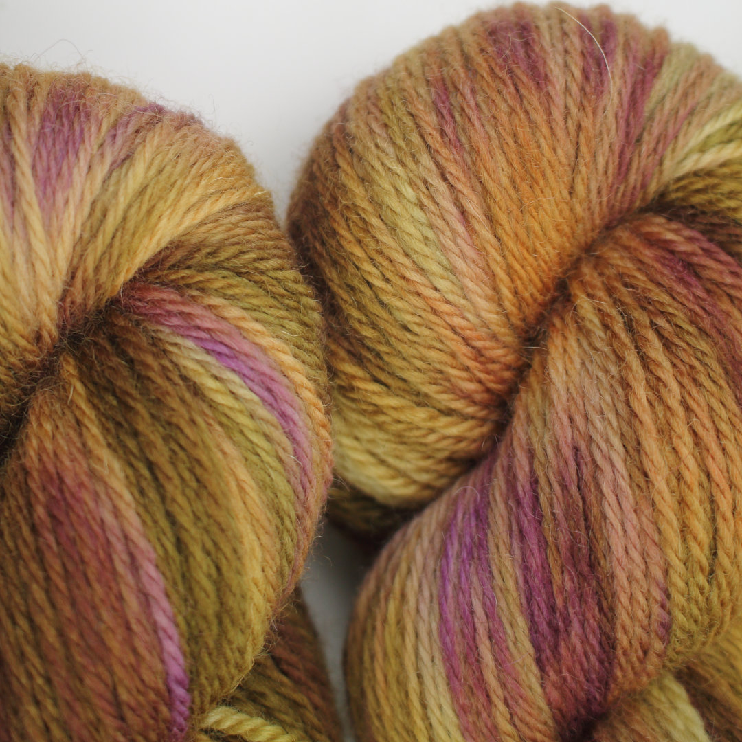 Variegated skeins of sandy brown, mossy green, and soft pink.