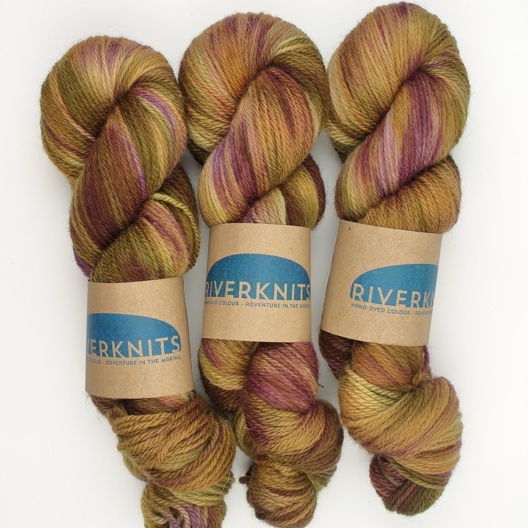 Variegated skeins of sandy brown, mossy green, and soft pink.