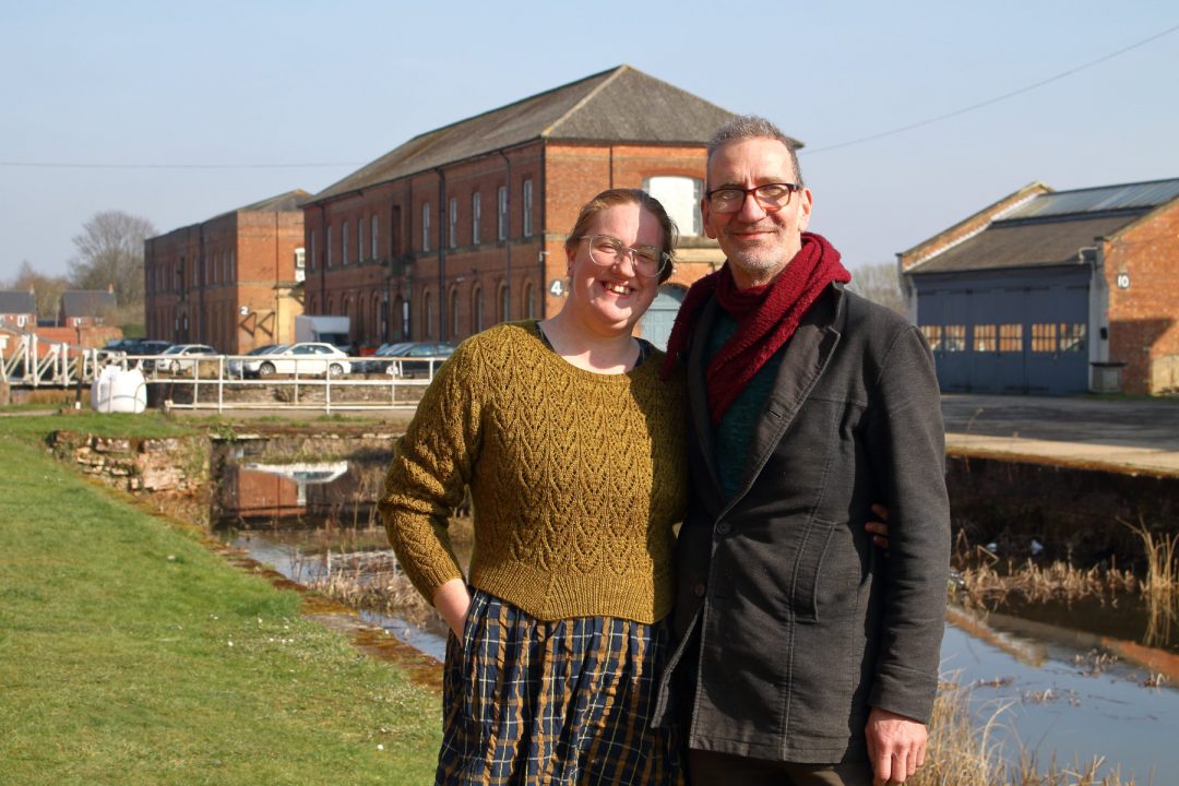 Becci and Markus standing outside their studio and smiling.
